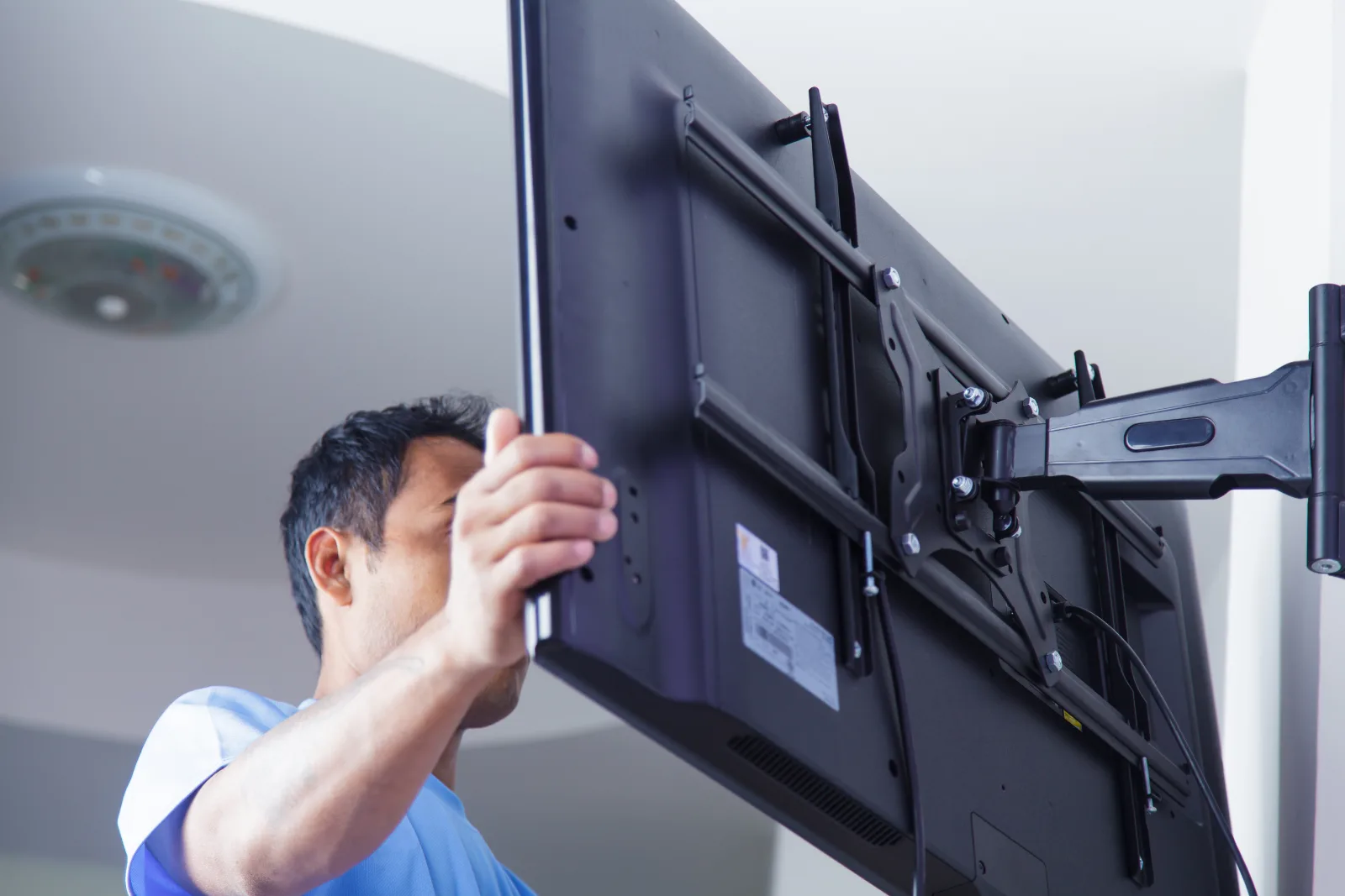 Man Installing wall mount TV